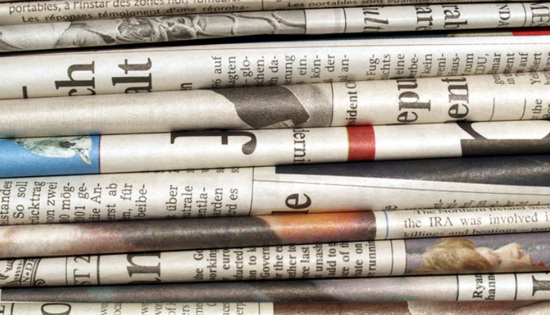 a close up photo of a stack of newspapers. Only the folds of the paper are visible