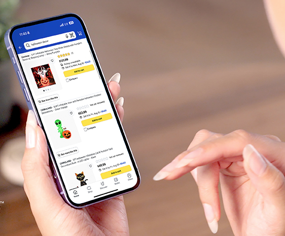 A photo of a well manicured pair of hands holding a phone upon which the best buy shopping screen can be seen.