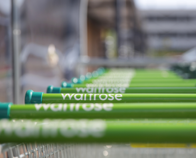 A photo of lined up handles of waitrose shopping carts
