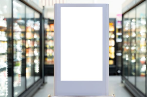 An image of a grocery store freezer aisle. In the middle is a bright white digital screen .