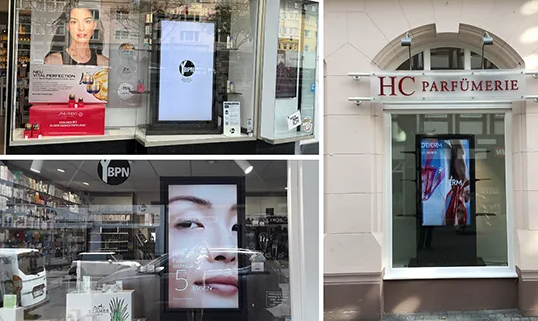 An image of three examples of in window digital screens each showing advertising to the street outside.