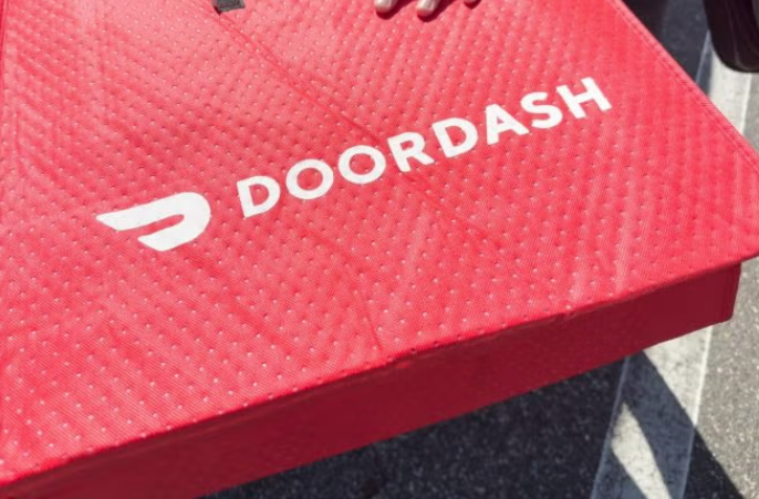 The doordash logo on a read messenger bag